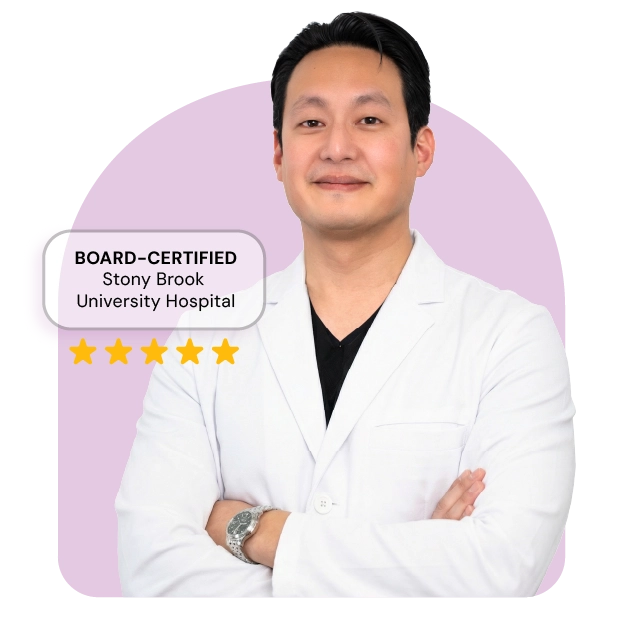 A healthcare provider stands against a neutral background, wearing a white medical coat. He has a calm and approachable expression, and his arms are gently crossed. The image conveys confidence, professionalism, and warmth suitable for a clinical
