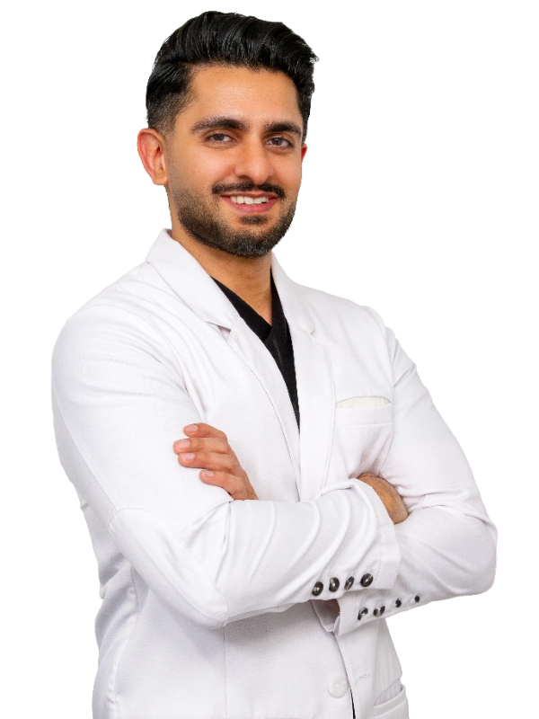Professional headshot of Dr. Mehta wearing a white lab coat, smiling at the camera against a grey background. This is a standard medical professional portrait used for clinic or practice identification.